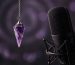 An amethyst pendulum beside a recording microphone.