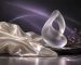 An abstract glass sculpture and ivory fabric in lavender light.