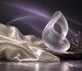 An abstract glass sculpture and ivory fabric in lavender light.